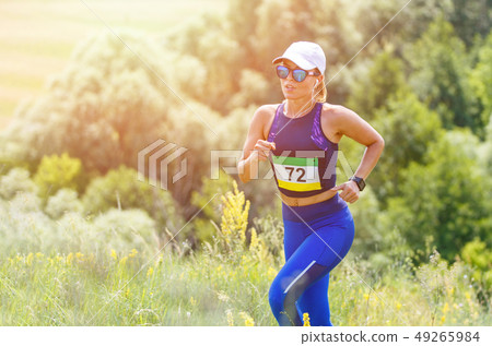 Young slim woman running trail race contest 49265984