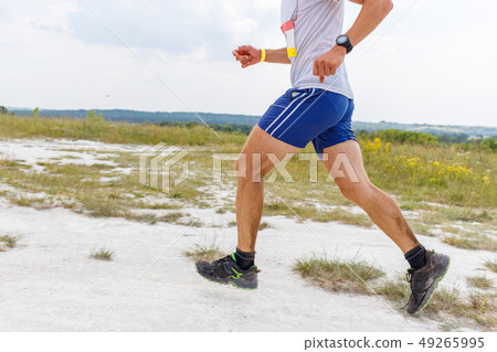 Legs of man running on sandy ground Legs of man running on sandy ground 49265995