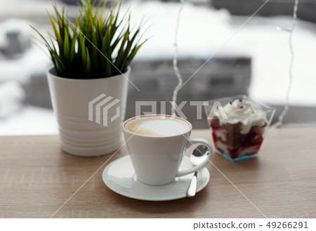 White cup of hot cappuccino on white saucer and 49266291