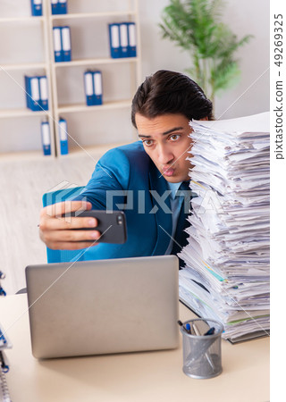 Young handsome businessman unhappy with excessive work Young handsome businessman unhappy with excessive work 49269325