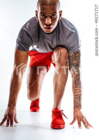 Sportive man starting to run from a low Sportive man starting to run from a low 49271717