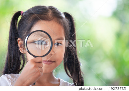 asian girl looking through a magnifying glass asian girl looking through a magnifying glass 49272785