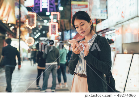 woman texting sms cellphone in city at night 49274060