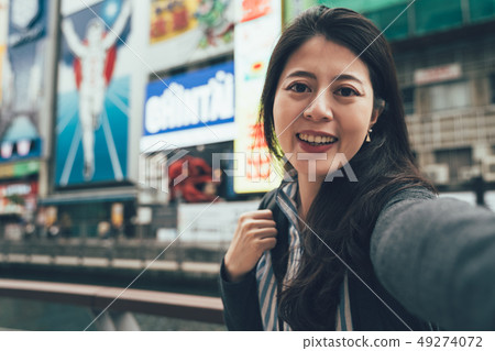 smiling woman taking selfie outdoors 49274072