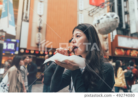 female model eating octopus ball dumpling 49274080