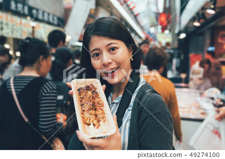 tourist smiling sharing delicious yakitori 49274100