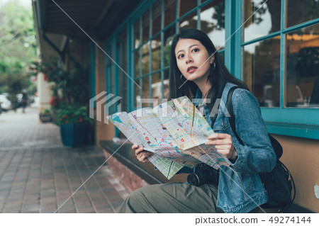 tourist sit holding paper map searching direction 49274144
