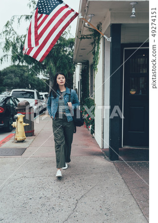 woman walking on street with fire hydrant in back 49274151