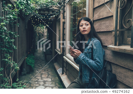 asian girl relying on wooden house wall asian girl relying on wooden house wall 49274162