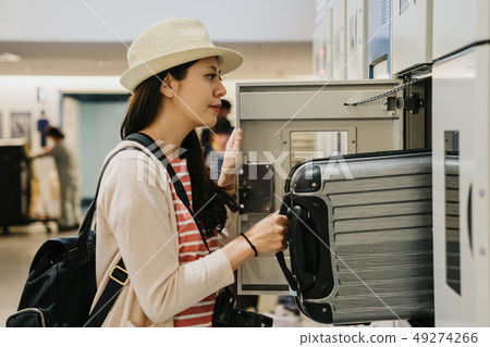 woman in straw hat uses safety locker 49274266