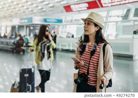 tourist girl using smartphone checking flight 49274270