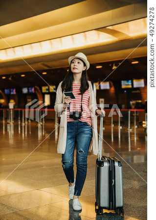 woman waiting for flight at airport terminal 49274278