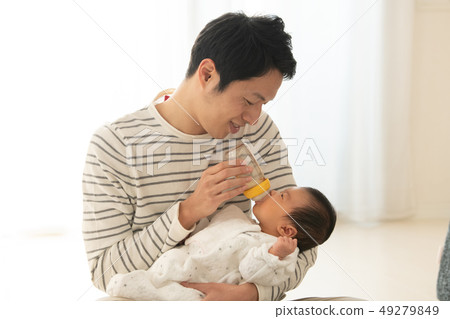 Father childcare nursery men who causes the baby to drink milk in a feeding bottle Father childcare nursery men who causes the baby to drink milk in a feeding bottle 49279849