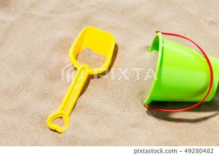 close up of toy bucket and shovel on beach sand 49280482