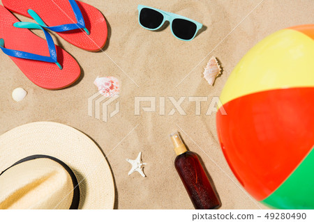 hat, flip flops and shades and beach ball on sand hat, flip flops and shades and beach ball on sand 49280490
