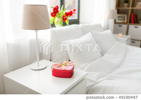 gift in shape of heart on bedside table in bedroom 49280497