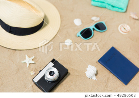 camera, passport, sunglasses and hat on beach sand camera, passport, sunglasses and hat on beach sand 49280508