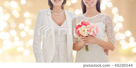 close up of happy lesbian couple with flowers close up of happy lesbian couple with flowers 49280544
