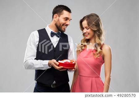 happy couple with chocolate box in shape of heart 49280570