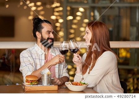 couple eating and drinking red wine at restaurant 49280714