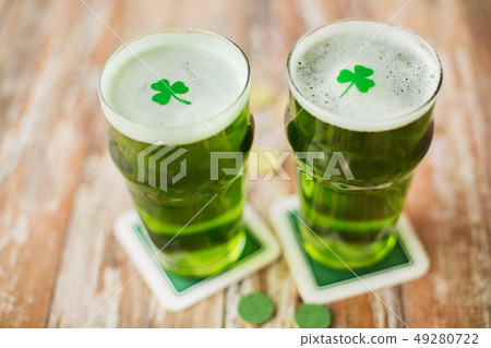 glasses of green beer with shamrock and gold coins glasses of green beer with shamrock and gold coins 49280722