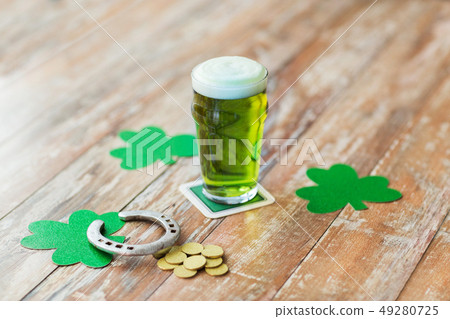 glass of green beer, horseshoe and gold coins 49280725