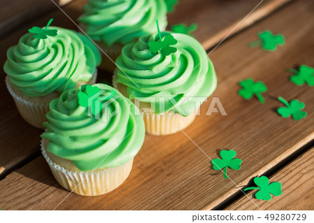 green cupcakes and shamrock on wooden table green cupcakes and shamrock on wooden table 49280729