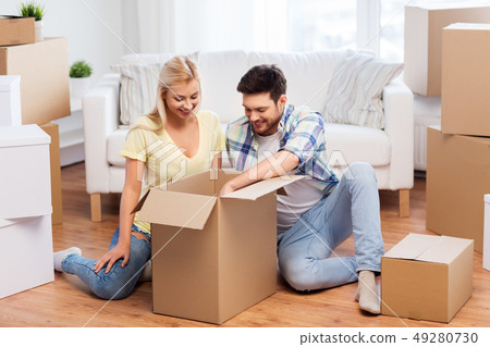 happy couple unpacking boxes at new home happy couple unpacking boxes at new home 49280730