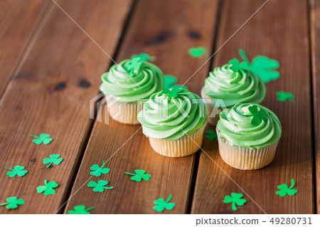 green cupcakes and shamrock on wooden table 49280731