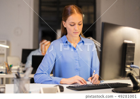 businesswoman at computer working at night office businesswoman at computer working at night office 49281001