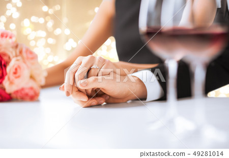 close up of couple holding hands at engagement 49281014