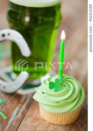 green cupcake with candle, beer and horseshoe 49281089