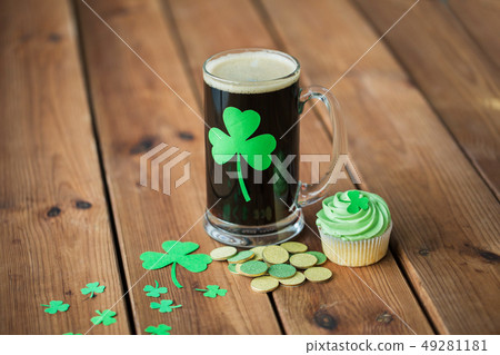 shamrock on glass of beer, green cupcake and coins 49281181