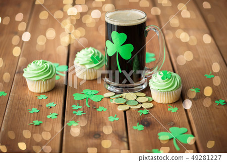 shamrock on glass of beer, green cupcake and coins shamrock on glass of beer, green cupcake and coins 49281227