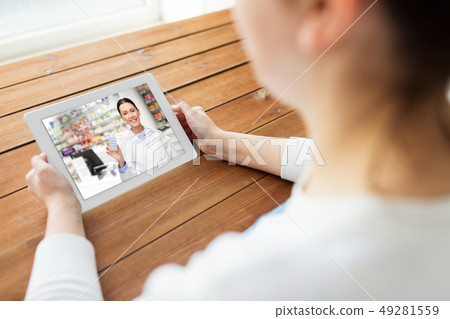 woman having video chat with pharmacist on tablet woman having video chat with pharmacist on tablet 49281559