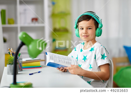 boy in headphones with textbook learning at home boy in headphones with textbook learning at home 49281683