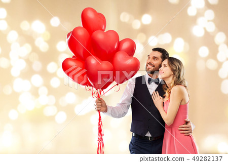 happy couple with red heart shaped balloons happy couple with red heart shaped balloons 49282137