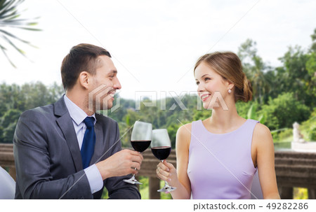 young couple with glasses of wine at restaurant young couple with glasses of wine at restaurant 49282286