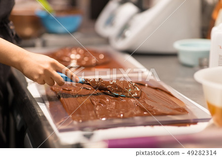 confectioner makes chocolate dessert at sweet-shop 49282314