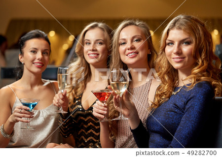 happy women drinks in glasses at night club happy women drinks in glasses at night club 49282700