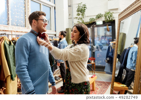 couple choosing bowtie at vintage clothing store couple choosing bowtie at vintage clothing store 49282749