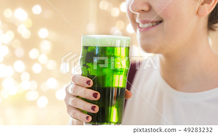 close up of woman with green beer in glass close up of woman with green beer in glass 49283232