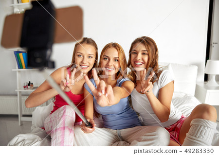 teenage girls taking selfie by smartphone at home teenage girls taking selfie by smartphone at home 49283330