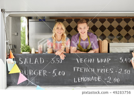 couple of happy young sellers at food truck couple of happy young sellers at food truck 49283756