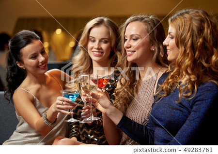 happy women clinking glasses at night club 49283761