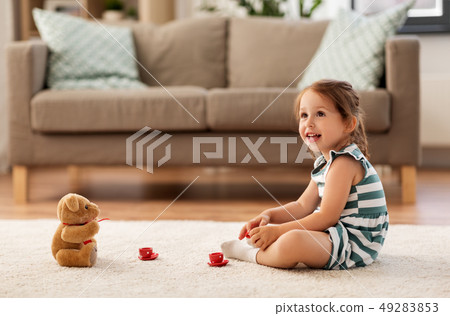 little girl playing with toy tea set at home 49283853