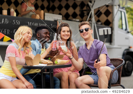 happy young friends taking selfie at food truck happy young friends taking selfie at food truck 49284029