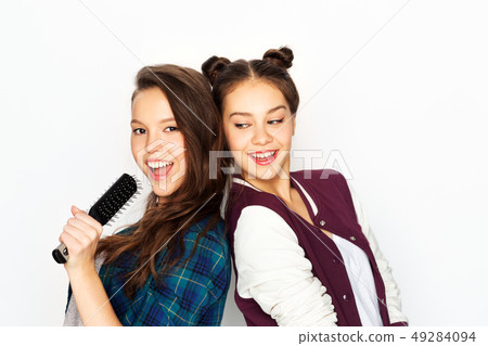 teenage girls singing to hairbrush and having fun teenage girls singing to hairbrush and having fun 49284094
