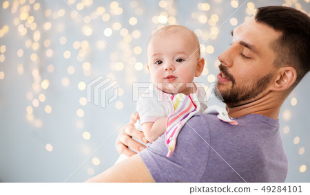 father with little baby daughter over lights 49284101