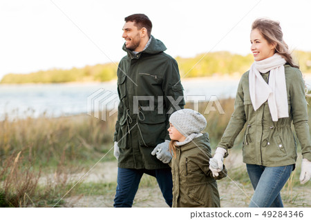 happy family walking along autumn beach happy family walking along autumn beach 49284346